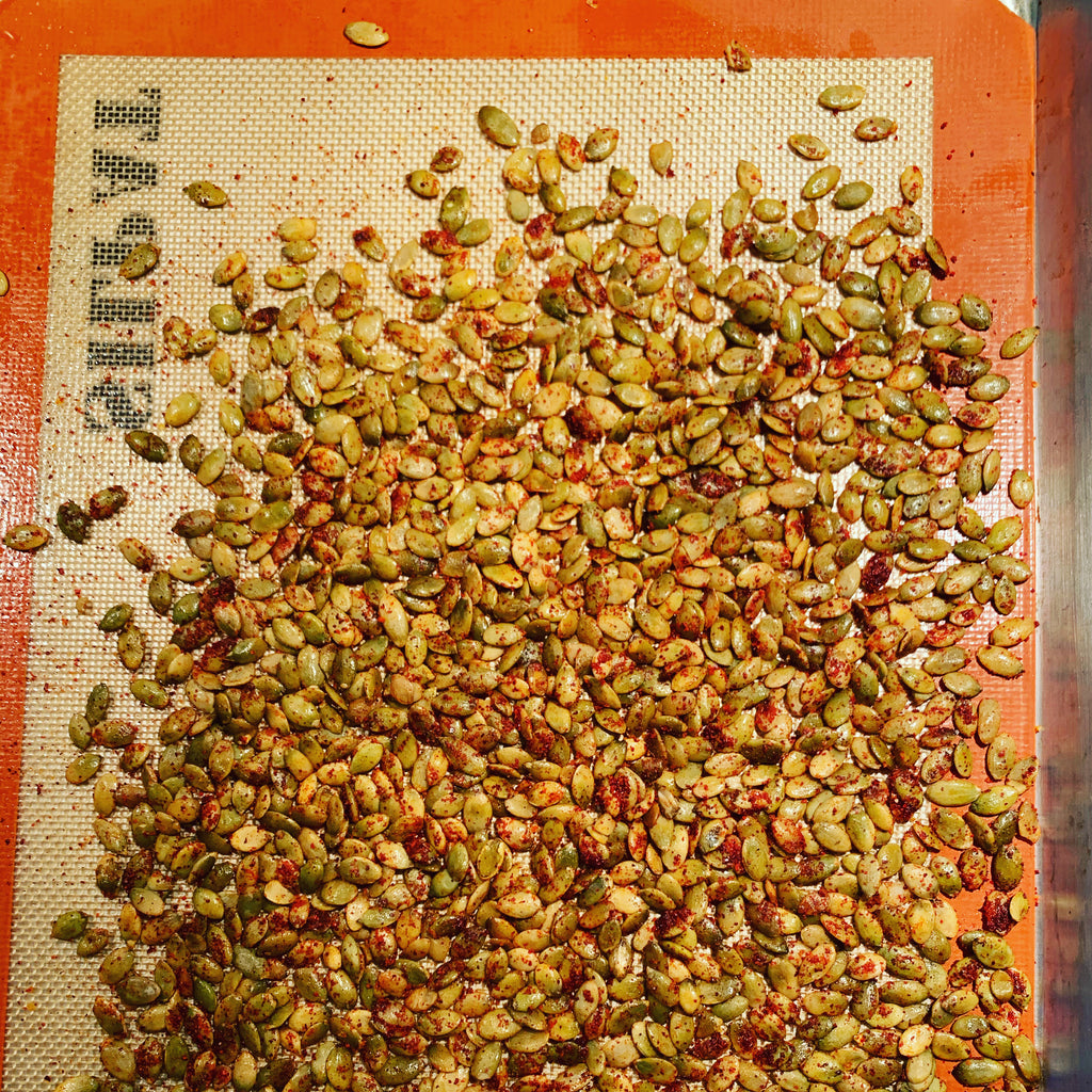 pumpkin seeds on sheet pan with chile powder