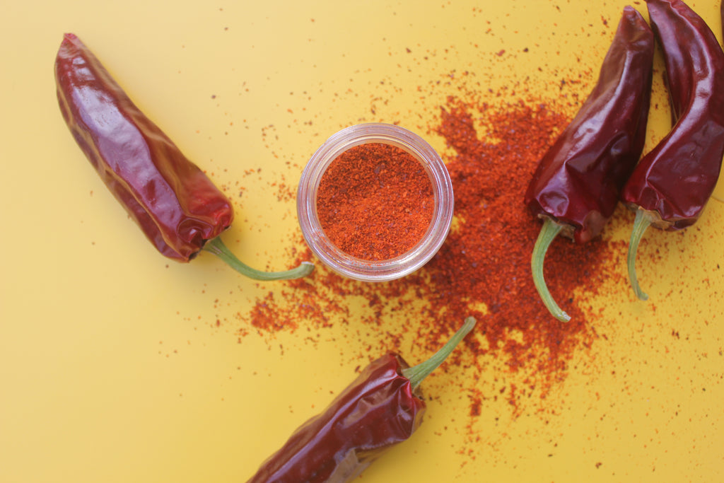 yellow background with dried chiles and orange chile powder