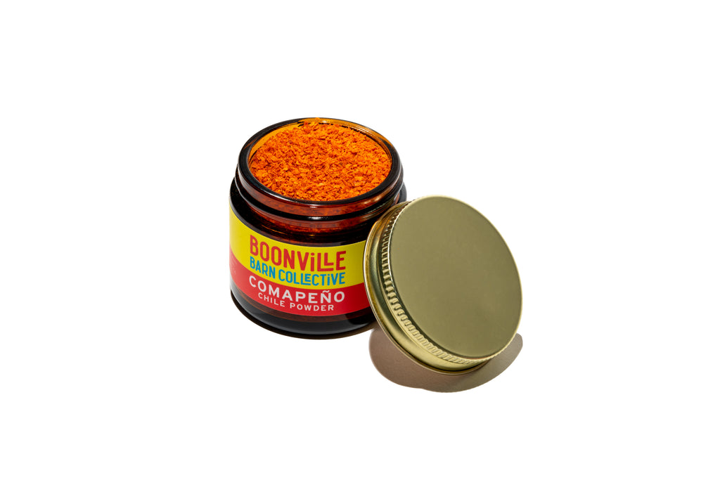 open jar of comapeno chile powder showing fine ground texture